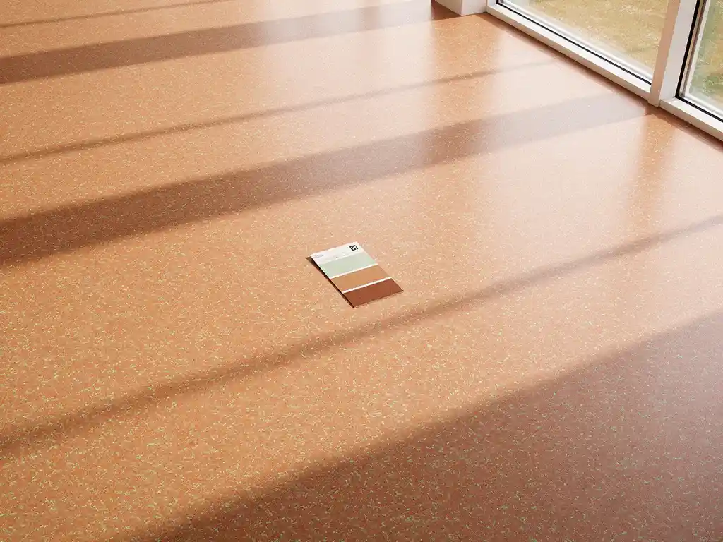 Terracotta linoleumvloer met saliegroen accent in modern interieur, architectenstalenkaart op het oppervlak, diagonale raamschaduwen.
